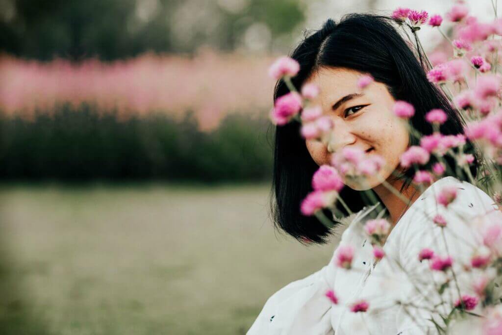 girl smiles through flowers